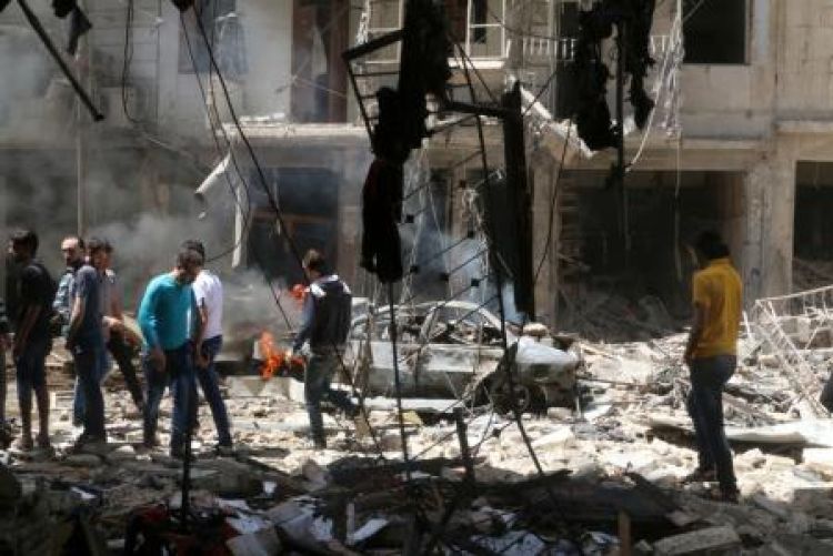 

 Pessoas em meio a destroços após ataques aéreos em Aleppo, Síria.