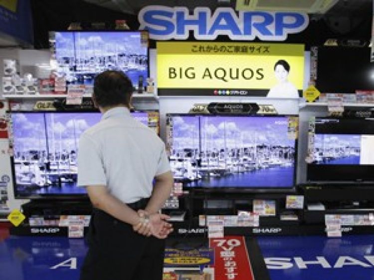 Homem observa televisores da Sharp em uma loja
de eletrônicos em Tóquio (Foto: Reuters)